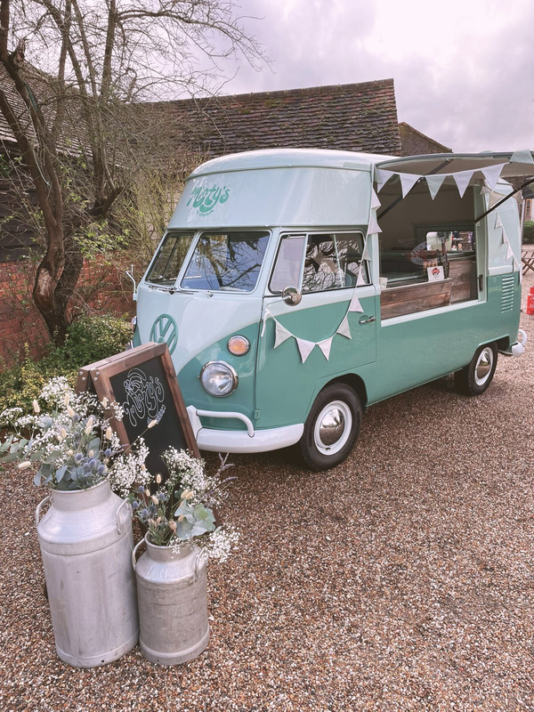 Minty's ice cream vintage vw Volkswagen van setup at a wedding event on the Essex / Suffolk border, showing it's bunting, flowers & milk churns.
